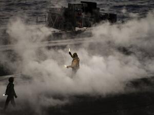A crew member of U.S. aircraft carrier USS Harry S Truman reacts after the takeoff of an F18 Hornet fighter jet from the flight deck of the ship in the eastern Mediterranean Sea on May 8, 2018. The Harry S Truman carrier strike group on May 3, began air operations in support of Operation Inherent Resolve, conducting flight operations against ISIS targets in Syria. The strike group includes a guided-missile cruiser and four guided-missile destroyers. (Aris MESSINIS / AFP)