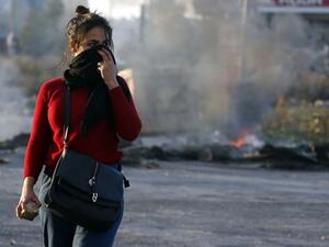 A Palestinian demonstrator covers her face during clashes with Israeli troops in Ramallah. (AFP)
