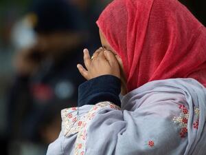 A Muslim woman weeps as she stands across the road from the Dean Street mosque when worshipers were gunned down in Christchurch  (AFP)