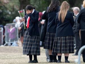 A schoolgirl gestures as mourners proceed during the funeral of Muhammad Haziq Mohd-Tarmizi at Memorial Park Cemetery in Christchurch on March 21, 2019. (AFP)