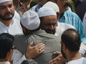 Mourners comfort the father (centre R) of Syed Areeb Ahmed, a Pakistani victim of the Al Noor Mosque attack in New Zealand, during his funeral in Karachi (AFP)