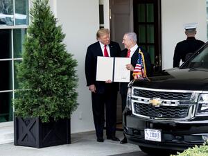 US President Donald Trump (L) and Israel's Prime Minister Benjamin Netanyahu hold up a Golan Heights proclamation outside the West Wing after a meeting in the the White House  (AFP)