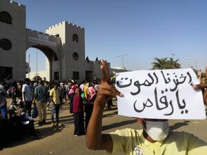 A Sudanese protester holds a placard during a demonstration in front of the military headquarters in the capital Khartoum on April 9, 2019. The writing on the placard reads in Arabic : "We have chosen death, hey dancer", referring to the president. (AFP)