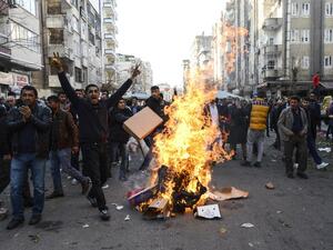 People protest near a fire during clashes between Turkish forces and Kurdish people in the center of Diyarbakir, during a protest against a curfew in the Sur district of Diyarbakir, on March 2, 2016. (AFP/Ilyas Akengin)
