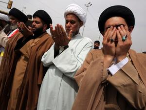 Shia clerics and supporters of Iraqi cleric Moqtada al-Sadr pray during a demo calling for governmental reform and elimination of corruption on March 25, 2016, outside the main gates of Baghdad's Green Zone. (AFP/Ahmad al-Ruvaye)