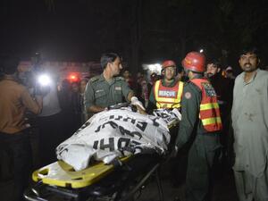 Pakistani rescuers use a stretcher to shift a body from a bomb blast site in Lahore on March 27, 2016. (AFP/Arif Ali)