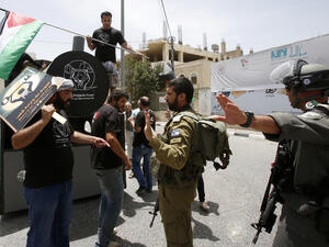 Israeli soldiers and Palestinians confront one another during a symbolic protest to mark Nakba Day (AFP/File Photo)