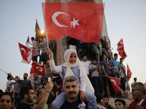 A child waves Turkish flags in Taksim square in Istanbul on July 16, 2016 during a demonstration in support to Turkish president. (AFP photo)