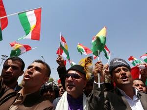 Iraqi Kurdish protesters wave flags of their autonomous Kurdistan region during a demonstration (AFP File Photo)