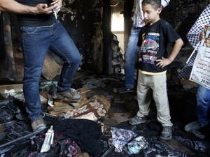 Palestinians inspect the damage as they stand in a house in the West Bank village of Duma set on fire in an apparent attack by Jewish terrorists, which killed 18-month-old Palestinian toddler Ali Saad Dawabsha on July 31, 2015. (AFP/Thomas Coex)