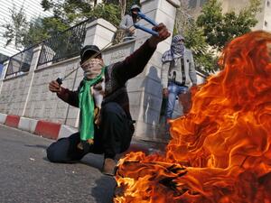 A Palestinian protestor uses a sling shot to throw stones towards Israeli security forces during clashes after the Friday prayers in the city centre of the West Bank town of Hebron. (HAZEM BADER / AFP)