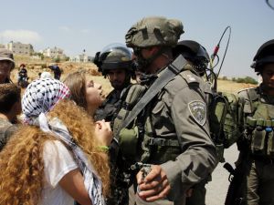 17-year-old Ahed Tamimi (C) protesting before Israeli forces in the West Bank village of Nabi Saleh, north of Ramallah, on May 12, 2017, after a demonstration following Friday prayers in solidarity with Palestinian prisoners on hunger strike in Israeli jails (Abbas Momani/AFP)