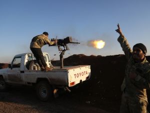 Turkish-backed fighters from the Free Syrian Army stand in the Tal Malid area, north of Aleppo, as they fire towards Kurdish People's Protection Units (YPG) positions in the village of Um al-Hosh, in the area of Afrin, on Jan. 20, 2018 (Nazeer al-Khatib / AFP)
