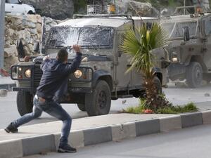 Palestinians throw stones at Israeli army vehicles after forces entered the village of Halhoul in the occupied West Bank on Feb. 07, 2018. A Palestinian stabbed a security guard at the entrance to an Israeli settlement and was shot dead in the latest violence in the occupied West Bank, Israel's military said.
(HAZEM BADER / AFP)