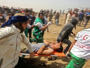 Palestinians evacuate an injured protester during clashes with Israeli security forces (AFP/File Photo)	