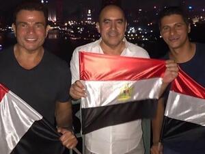 عمرو دياب ودينا الشربيني يلوحان بعلم مصر والأخيرة بقميص النوم