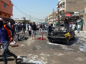 Iraqi civilians check the site of an explosion in Baghdad on August 28, 2013. (AFP/Sabah Arar)