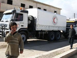 Syrian children walk in the street as a United Nations and Syrian Red Crescent inter-agency aid convoy arrives in the town of Utaya, in the militant-held enclave of Eastern Ghouta, Feb. 14, 2018 (AFP)
