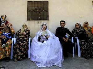 Around the couple, guests took photos with mobile phones while little girls also made-up with darkened eyebrows and colored lips danced to the beat of the music (AFP)