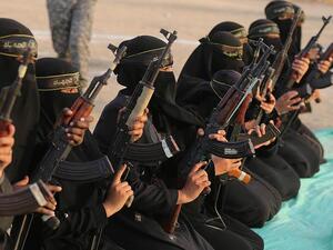 The women of the al-Quds Brigades holding Kalashnikov rifles and poised for action during the exercise at Khan Yunis on the southern section of the Gaza Strip (Shutterstock)