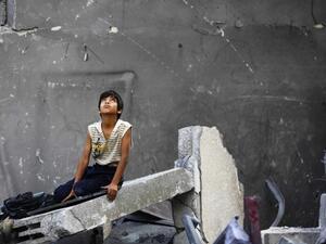 A Palestinian boy sits on rubble following an Israeli air strike in Gaza City, June 22, 2014. (AFP/File)