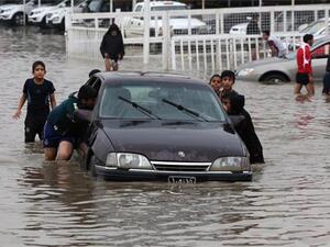 Iraqi children push a car through Baghdad during a similar flood in November 2013 (AFP / Ahmad Al-Rubaye)