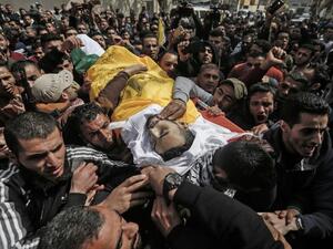 Palestinian mourners carry the body of Mousa Mousa,23, during his funeral in Deir al-Balah in the central Gaza Strip (AFP)