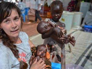 An MSF worker holds a baby outside a clinic in Juba, South Sudan. (AFP/File)