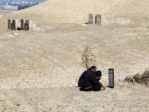 Iraqi men sitting at the grave of their brother, a former policeman who was killed by al-Qaeda sympathizers in 2008 in the Anbar province. (AFP PHOTO/AHMAD AL-RUBAYE)