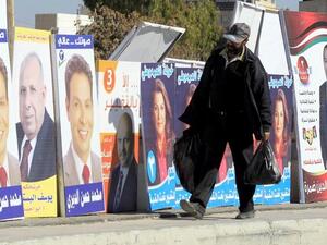A Jordanian man walks past electoral campaign posters in Amman. (AFP PHOTO/KHALIL MAZRAAWI)
