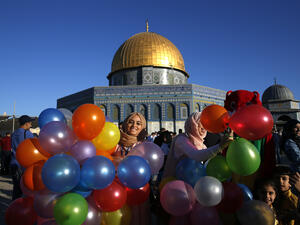 A Palestinian Woman Holding Balloons in front of the Dome of the Rock at Al Aqsa Mosque in Jerusalem. (AFP/ Ahmad Gharabli)