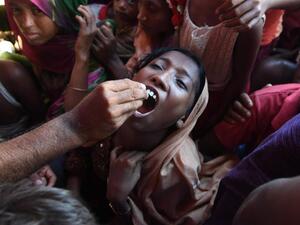 A Rohingya refugee receives an oral cholera vaccine from a Bangladeshi volunteer at the Thankhali refugee camp. (Indranil Mukherjee / AFP)