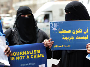 Yemeni women hold placards during a protest on 25 June 2014 in the capital Sanaa in solidarity with Al Jazeera journalists jailed in Egypt at the time. (AFP/File)