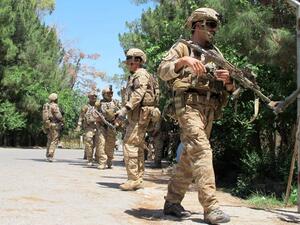 This file photo taken on May 13, 2015 shows Afghan soldiers walking at the scene of clashes between Afghan security forces and Taliban militants in Helmand province. (AFP/Noor Mohammed)