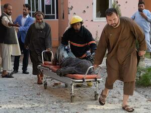 Afghan volunteers move a body from the scene of a suicide attack that targeted the national television station in Jalalabad on May 17, 2017. (AFP/Noorullah Shirzada)