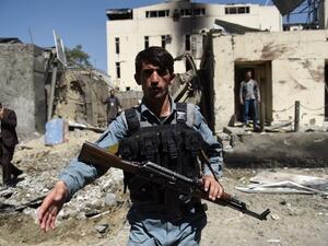 Afghan security personnel keep watch in front of the entrance to the charity organization following a car bomb blast that targeted the CARE International compound at Shar-e-Naw in Kabul on September 6, 2016. (AFP/Wakil Kohsar)