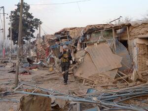 An Afghan security personnel walks along damaged buildings as he inspects the site of a bomb attack targeting the German consulate in Mazar-i-Sharif on November 11, 2016. (AFP/Farshad Usyan)