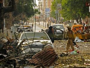 A Somali soldier responds to the Ambassador Hotel bombing in Mogadishu, Somalia. (AFP/Mohamed Abdiwahab)