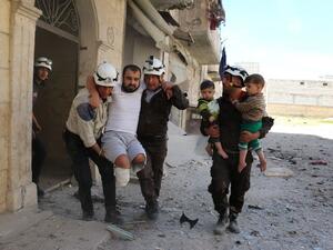 Volunteers evacuate a man and child following an airstrike in rebel-held eastern Aleppo. (AFP/Ameer Alhalbi)