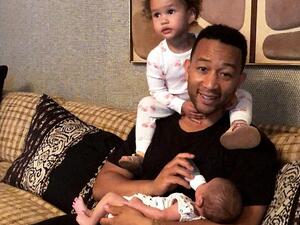 John Legend, 39, doted on his two young children Luna, two, and six-week-old son Miles in a clip his wife Chrissy Teigen, 31, posted to Instagram Friday (Instagram)