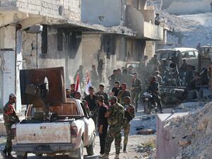 Syrian government forces gather amidst destruction in the largely deserted Palestinian refugee camp of Handarat, north of Aleppo. (AFP/File) 