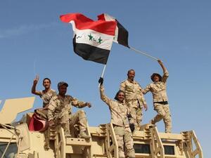 Iraqi government forces wave their national flags on March 10, 2016, after retaking the town of Zankura, northwest of Ramadi, from Daesh in Anbar province. (AFP/Moad Al-Dulaimi) 
