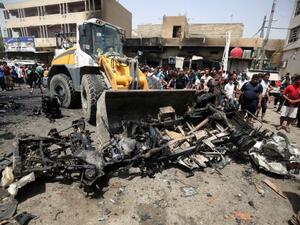 A bulldozer clears the wreckage following a car bomb attack in Sadr City, a Shiite area north of the capital Baghdad, on May 11, 2016 (AFP/Agmad Al Rubaye)