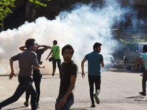 Egyptian protesters run for cover from tear gas fired by riot police during a Cairo demonstration, April 25, 2016. (AFP/Mohamed el-Shahed)