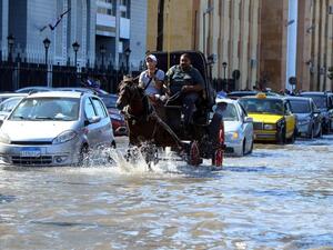Egyptian men ride a horse carriage in a flooded street in Egypt's northern coastal city of Alexandria, following heavy rains, on October 25, 2015. (AFP/File)