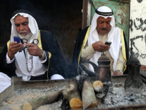 Two elderly Palestinian refugees hold mobile phones along with their traditional house keys in Gaza. (AFP/File)