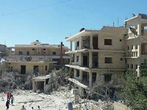 People gathering in front of the damaged building of a maternity hospital supported by Save the Children after it was hit by an air raid in the rebel-held town of Kafar Takharim, in Idlib province of northwest Syria on July 29, 2016. (AFP/File)  