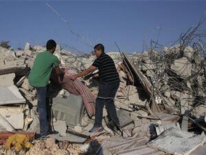 Members of a Palestinian family collect their belongings near the rubble of their house after it was demolished by Israeli forces, in Kafr Kanna. (AFP/file) 