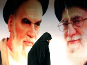 An Iranian woman walks past a giant poster showing supreme leader Ayatollah Ali Khamenei (R) and the founder of Iran's Islamic Republic, Ayatollah Ruhollah Khomeini (L), in Tehran. (AFP/File)