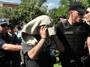 A Greek police officer escorts a Turkish soldier who fled to Greece by helicopter after a fail coup in July 2016. (AFP/File)
